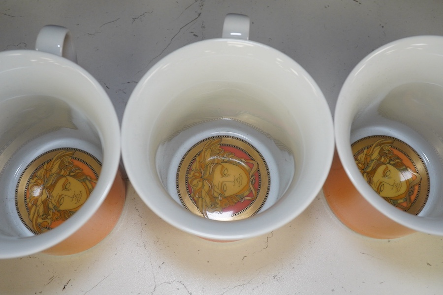 Five boxed Rosenthal for Versace mugs in various colours with Greek key pattern decoration together with a boxed miniature timepiece, 8.5cm high (6). Condition - good.